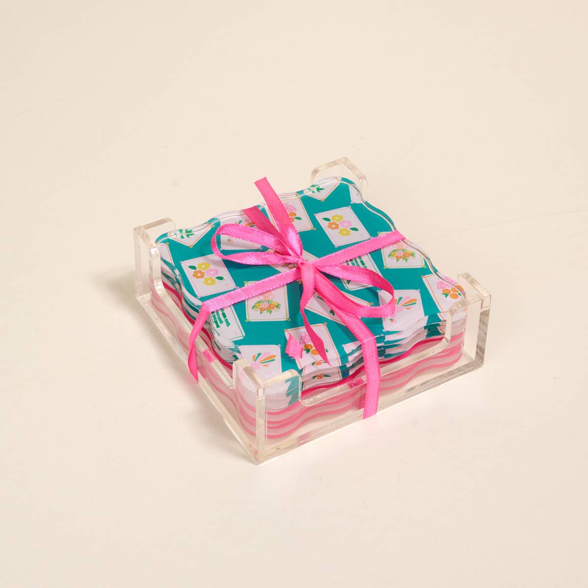 Stack of colorful coasters with a pink ribbon on a beige background