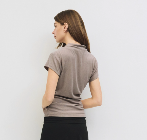 Woman wearing a brown t-shirt against a white background