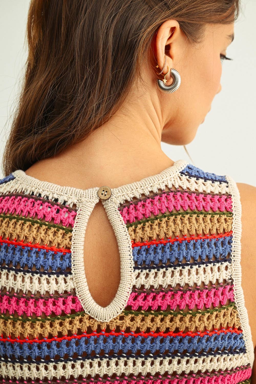 Multicolored striped sleeveless top worn by a person with a neutral background
