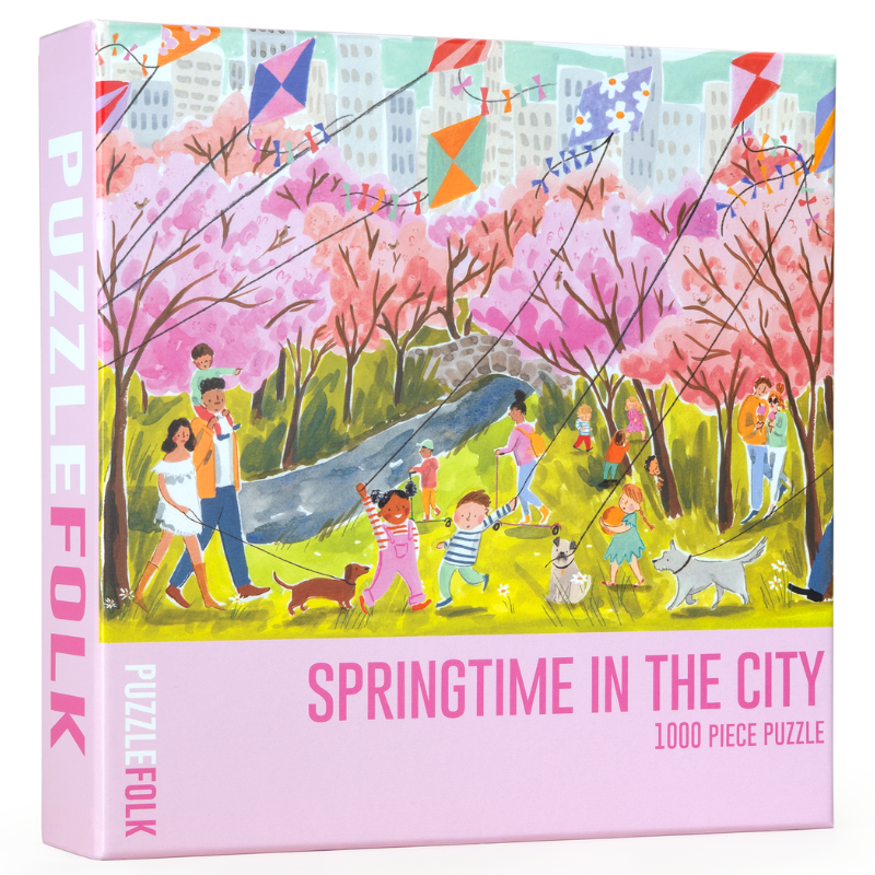 Puzzle box titled 'Springtime in the City' by Puzzle Folk with colorful illustration of people and kites.