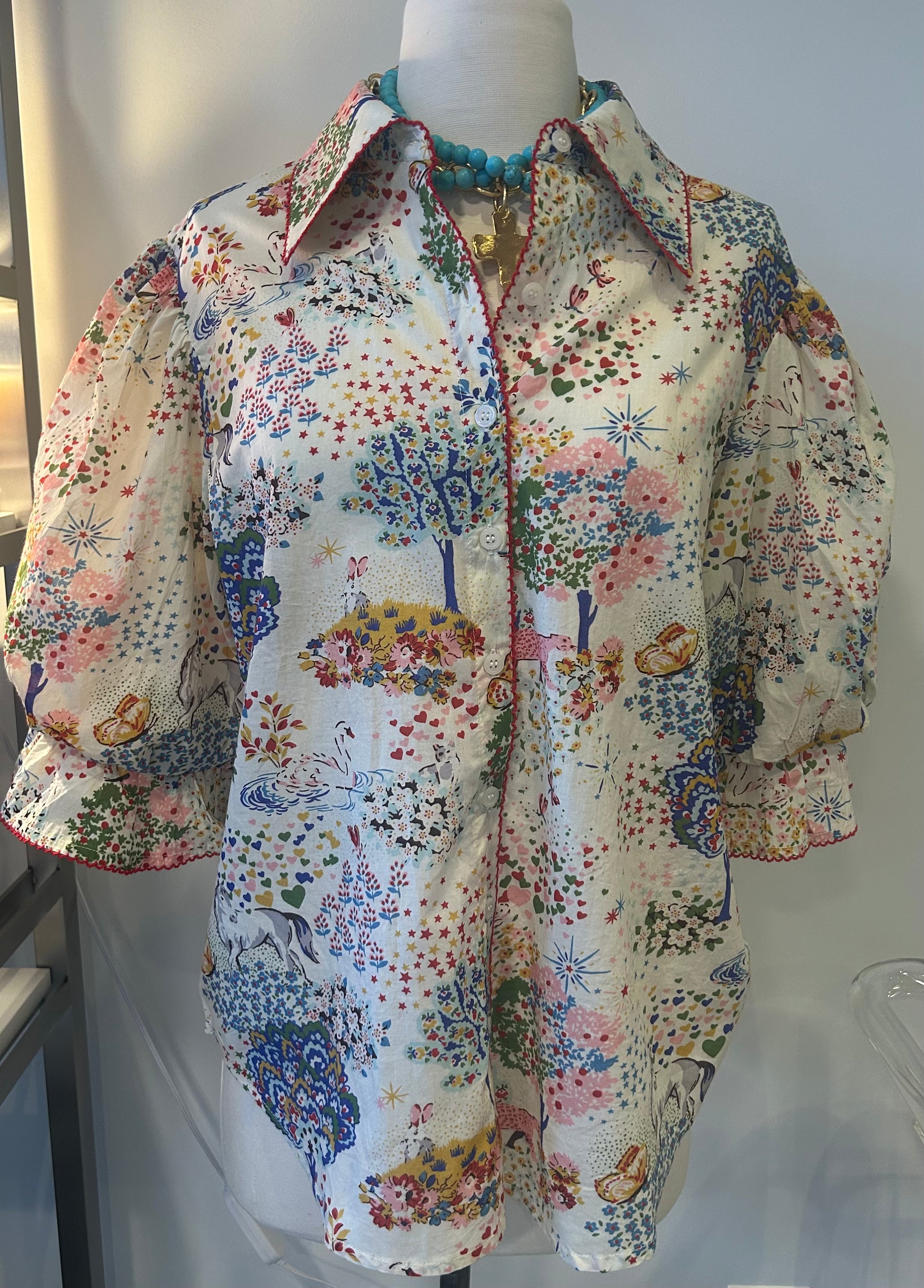 Floral patterned blouse on a mannequin against a white background