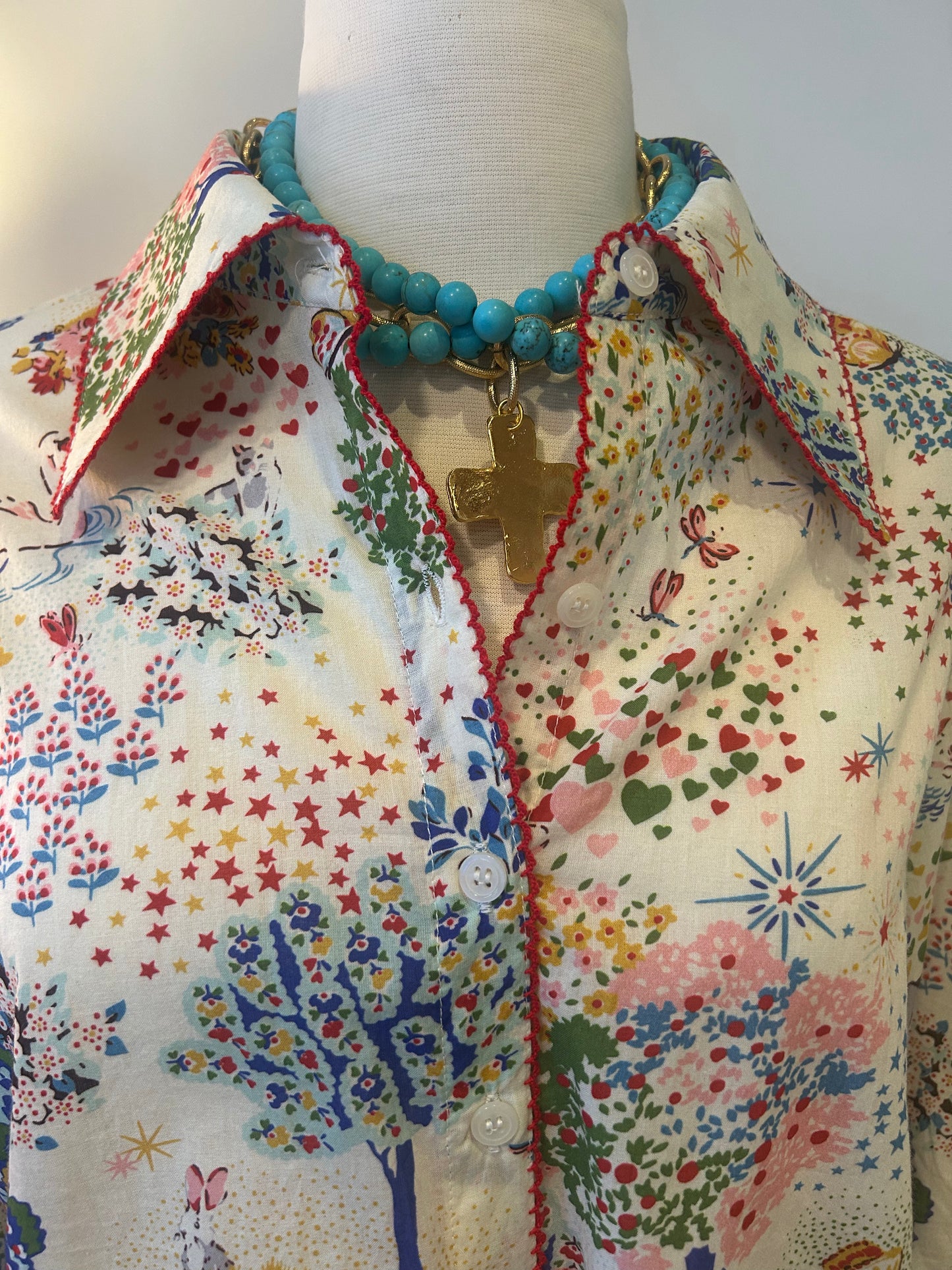 Mannequin wearing a colorful floral-patterned shirt with a necklace.