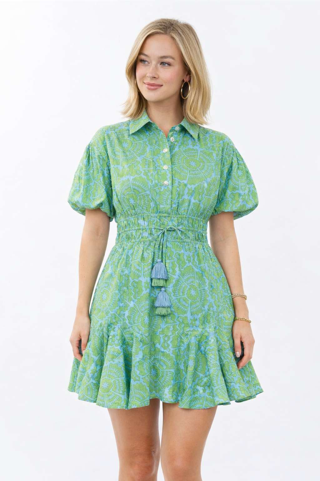 Woman wearing a green patterned dress on a white background
