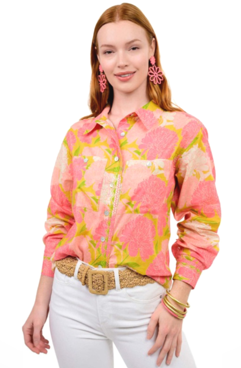 Woman wearing a pink floral blouse with white pants on a white background