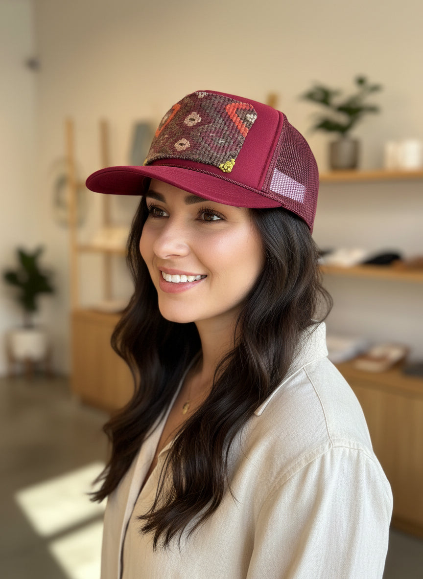 woman modeling maroon trucker with multi-color kilim patch
