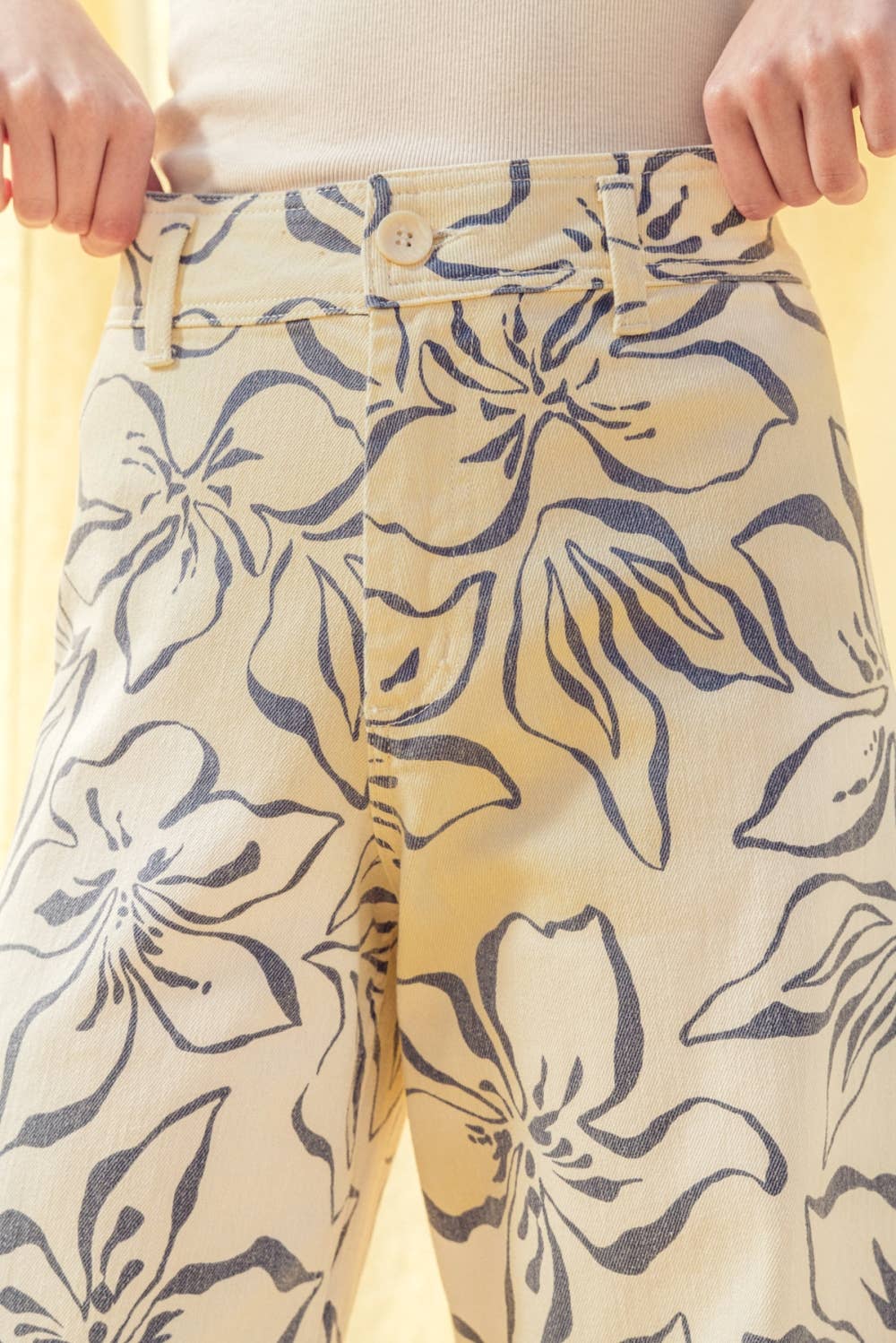 Floral-patterned pants being worn with a yellow background