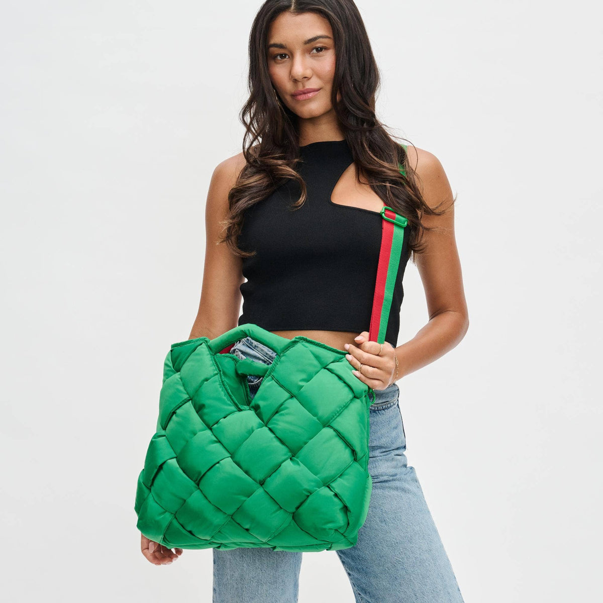A woman carrying a green woven nylon tote crossbody bag with a top handle.