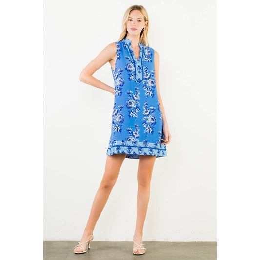 Woman wearing a blue floral dress against a white background