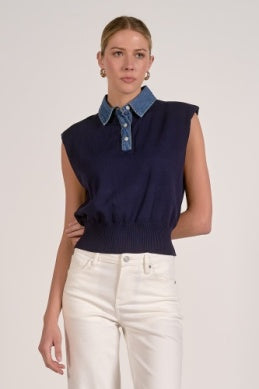 Woman wearing a navy sleeveless top with a denim collar against a white background