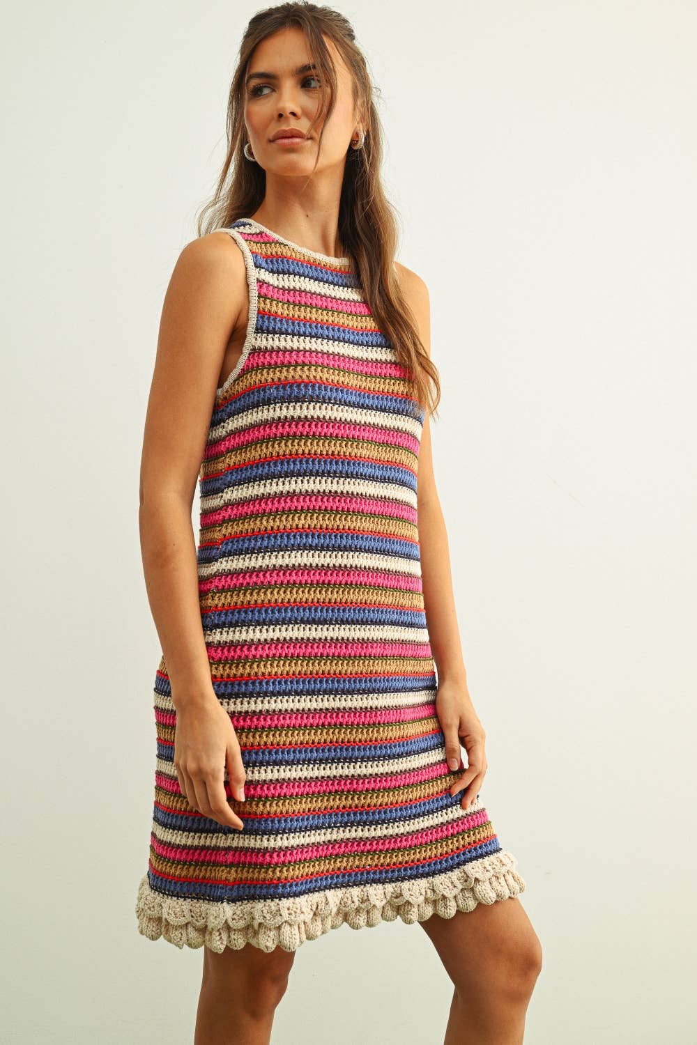 Woman wearing a colorful striped dress with a white background