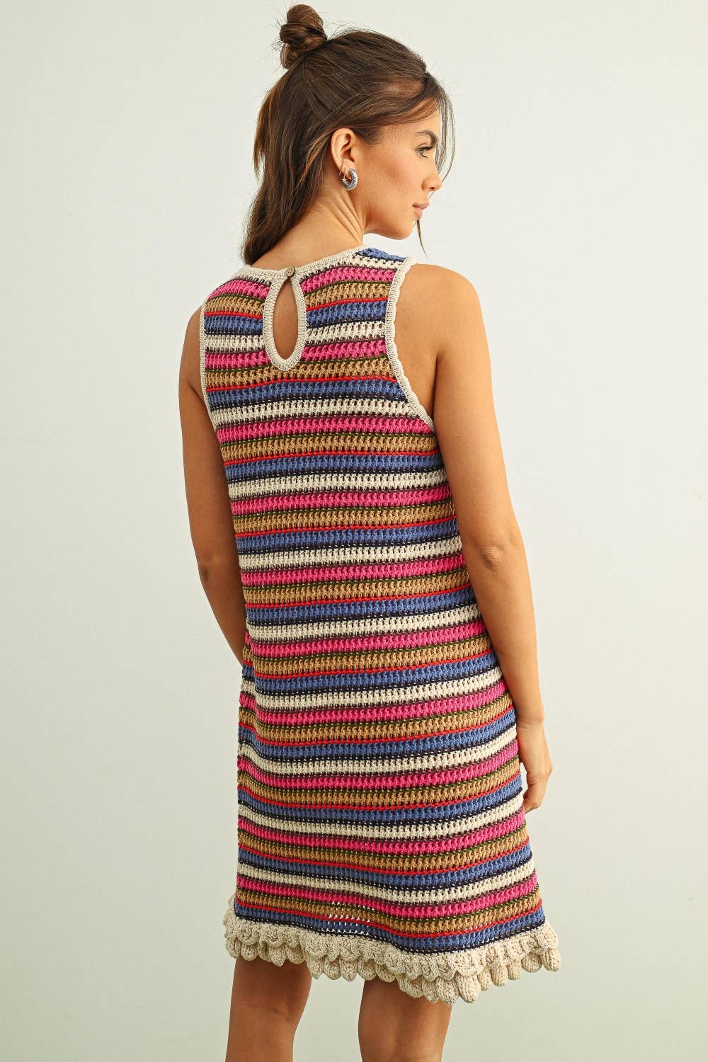 Woman wearing a colorful striped dress with a plain background